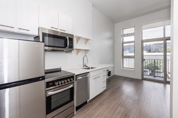 A kitchen with stainless steel appliances and white cabinets. at RiDE at RiNo Apartments, Colorado, 80216